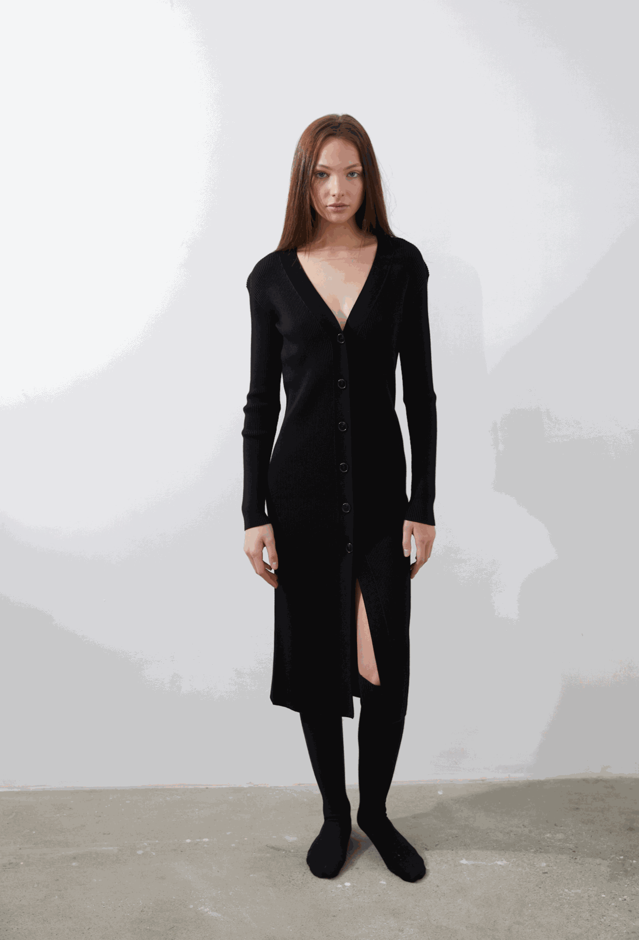 Leo Longline Cardigan in black featuring deep V-neckline and button fastenings, worn by model.