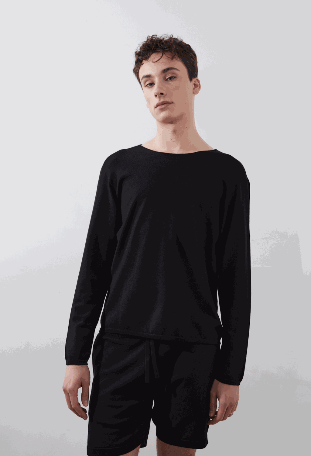 SOL CREWNECK in Black worn with shorts, showcasing sleek, seamless design and eco-friendly material.