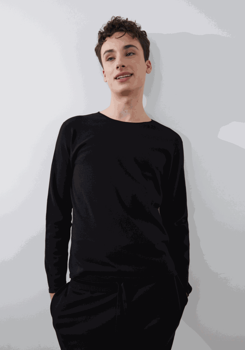 Black Sol Crewneck with full-length sleeves, worn by model standing against a white background.